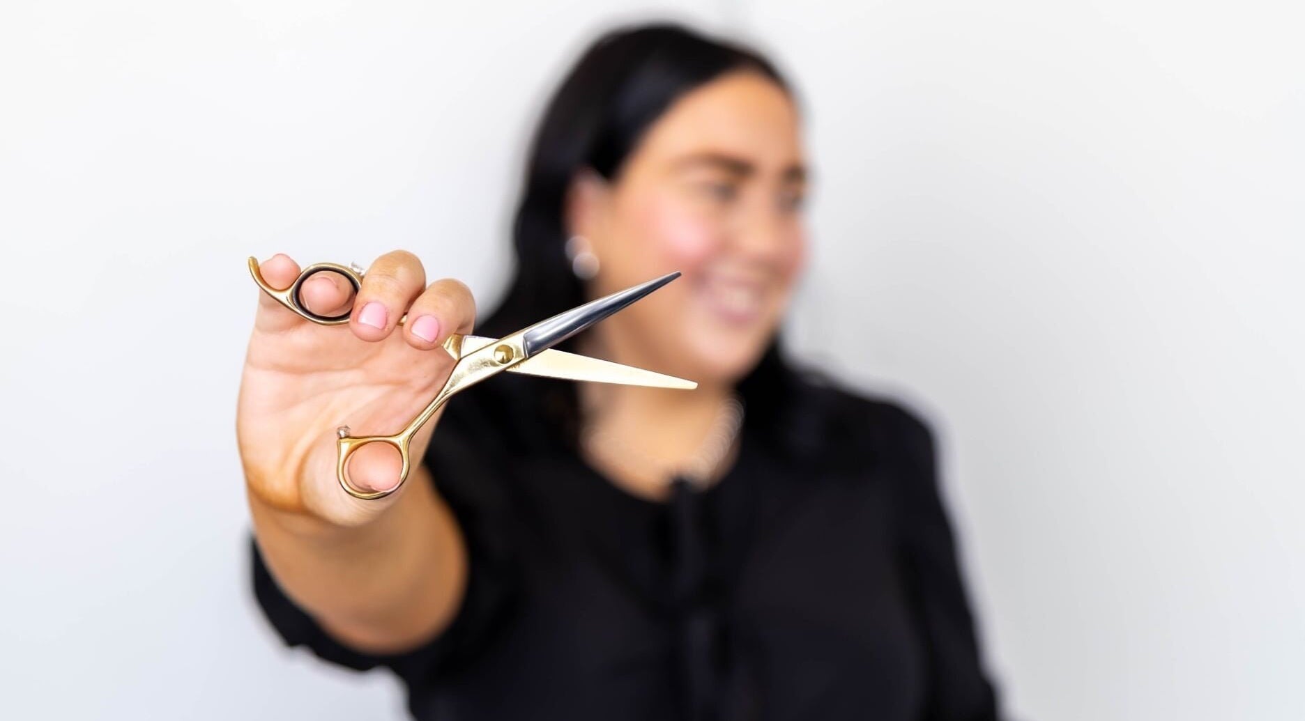 Stylist holding shears at The Hair Lounge in Emerald, Queensland, AU, offering expert haircut services.