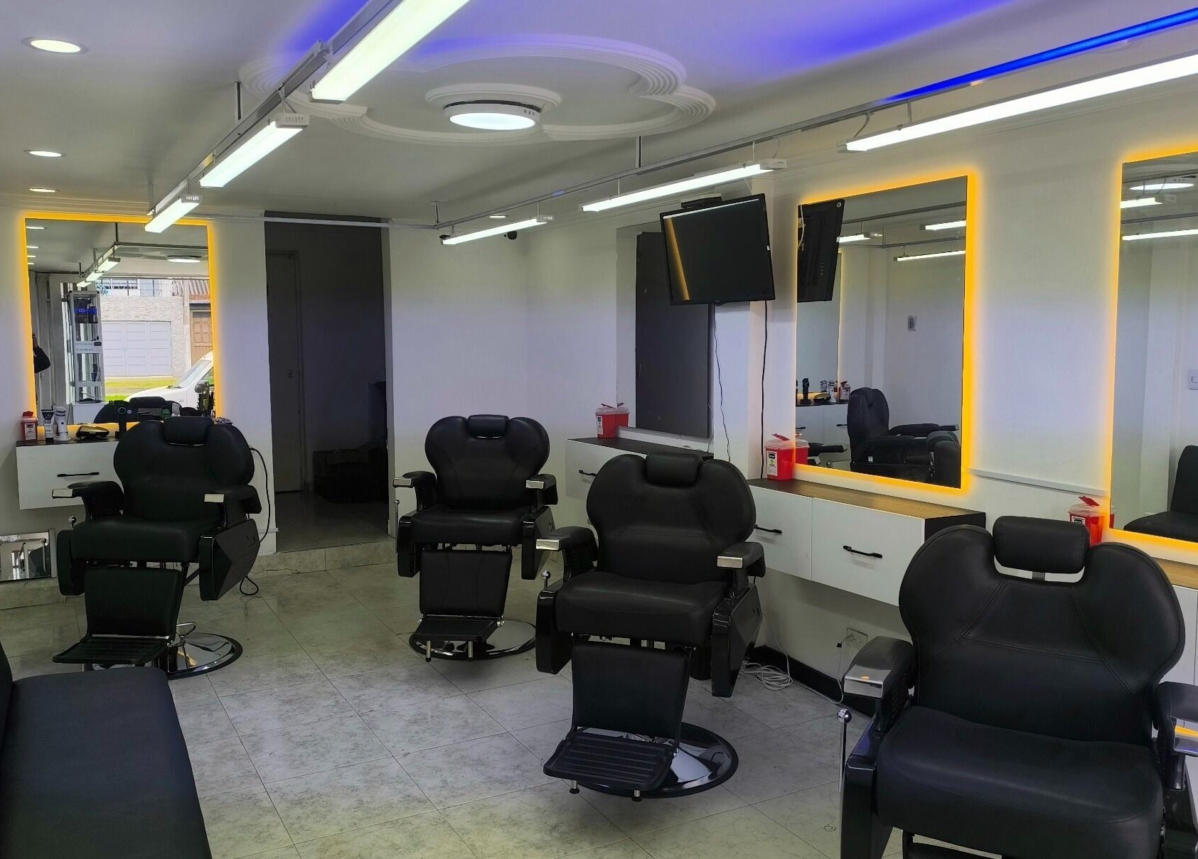 Silla de peluquería moderna en Barbería LUXFADE, Bogotá, Bogotá, CO, con espejos iluminados.