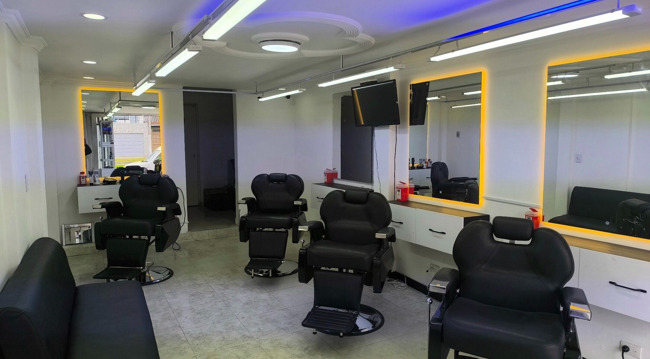 Silla de peluquería moderna en Barbería LUXFADE, Bogotá, Bogotá, CO, con espejos iluminados.