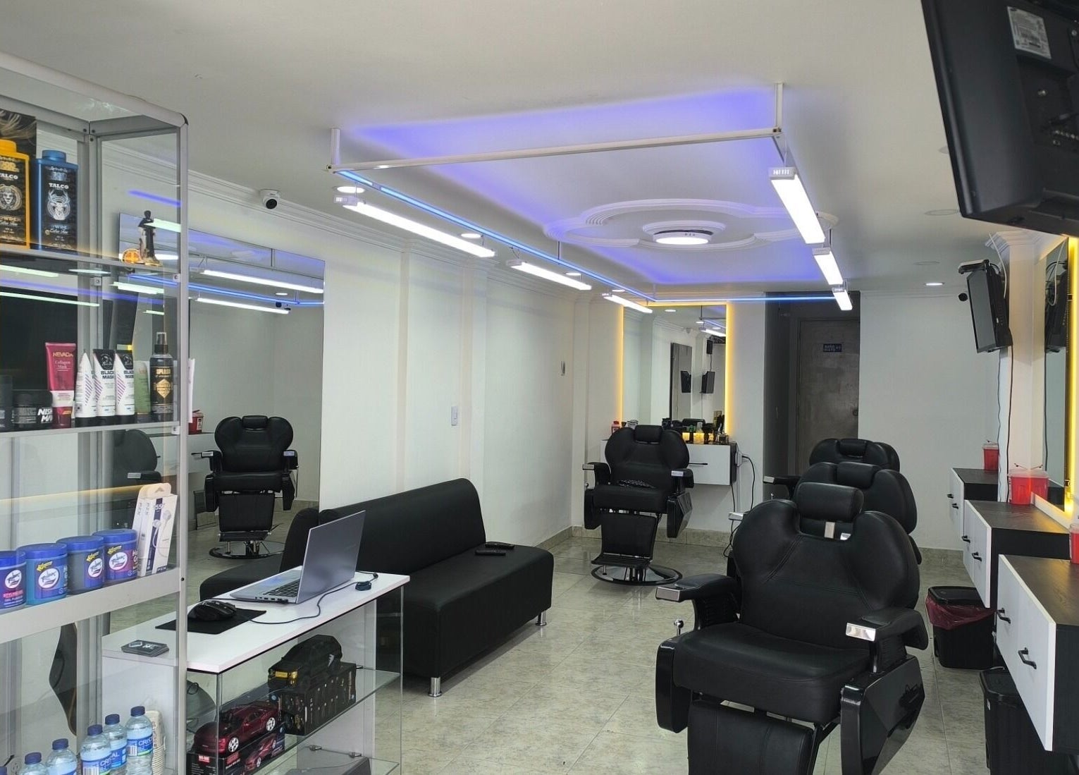 Interior moderno de Barbería LUXFADE en Bogotá, Bogotá, CO, con sillas de estilista y productos de belleza.