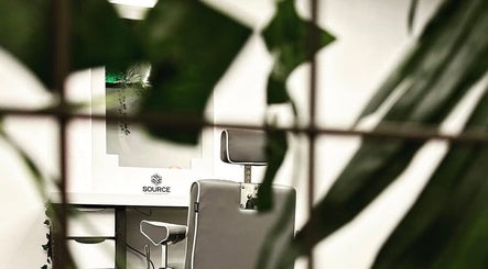 Stylish barber chair at Source Barbers in Aberdeen, Scotland, GB, surrounded by green plants.