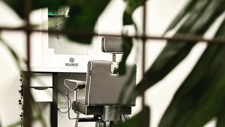 Modern barber chair at Source Barbers, Aberdeen, Scotland, GB, surrounded by lush greenery.