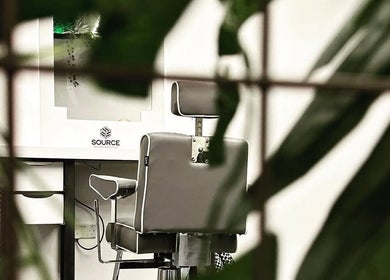 Modern barber chair at Source Barbers, Aberdeen, Scotland, GB, surrounded by lush greenery.