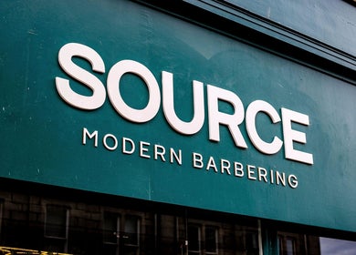 Entrance of Source Barbers in Aberdeen, Scotland, GB, showcasing modern signboard.