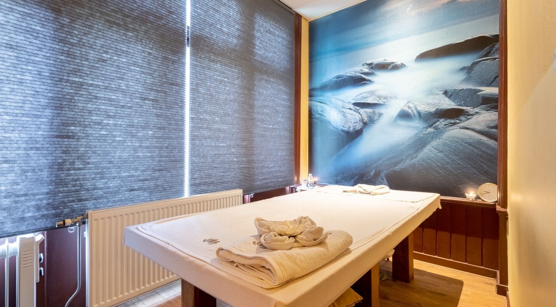 Massagekamer bij Cheeva Thai Wellness Spa, Amsterdam, Noord-Holland, NL met serene rotswanddecor.