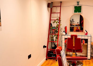 Cozy salon interior at Shortys - Leicester with red chair and vintage decor, located in Leicester, England, GB.