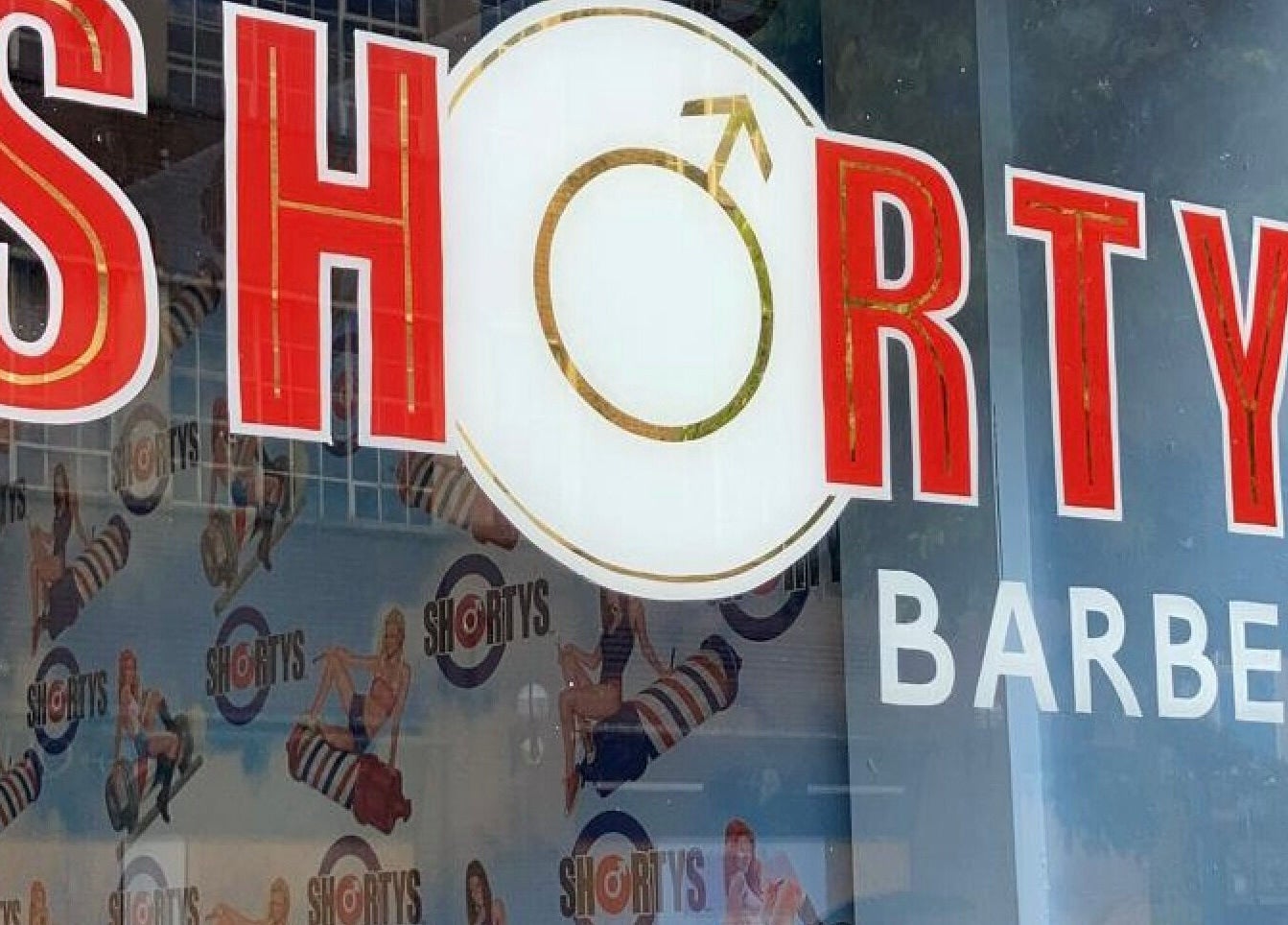 Close-up of vibrant Shortys - Hinckley barber sign in Hinckley, England, GB with retro design elements.