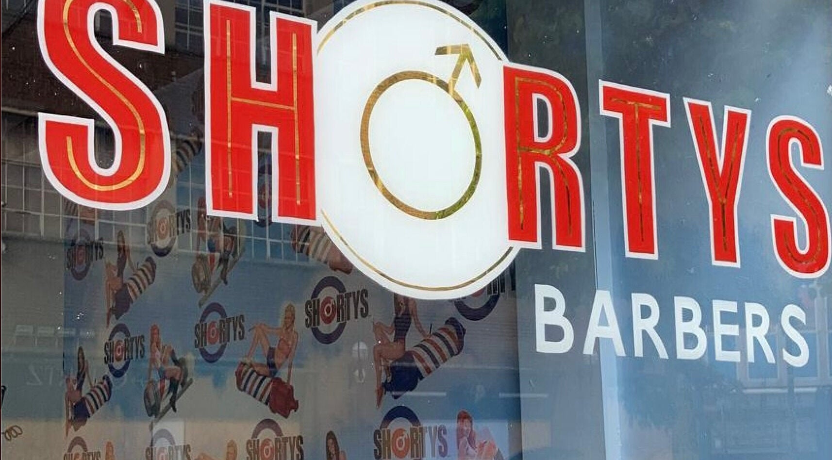 Close-up of vibrant Shortys - Hinckley barber sign in Hinckley, England, GB with retro design elements.