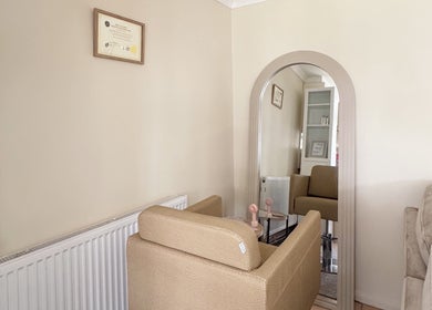 Elegant waiting area at Hair Extensions by Anarika in Hounslow, England, GB, featuring a comfy beige sofa and decor.