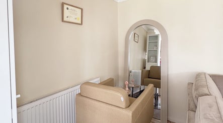 Elegant waiting area at Hair Extensions by Anarika in Hounslow, England, GB, featuring a comfy beige sofa and decor.