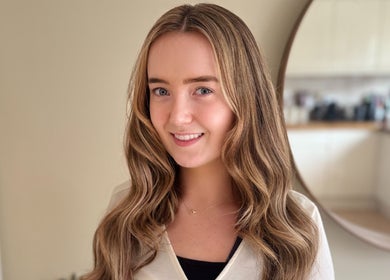 Smiling woman with wavy hair at Hair Extensions by Anarika, Hounslow, England, GB.