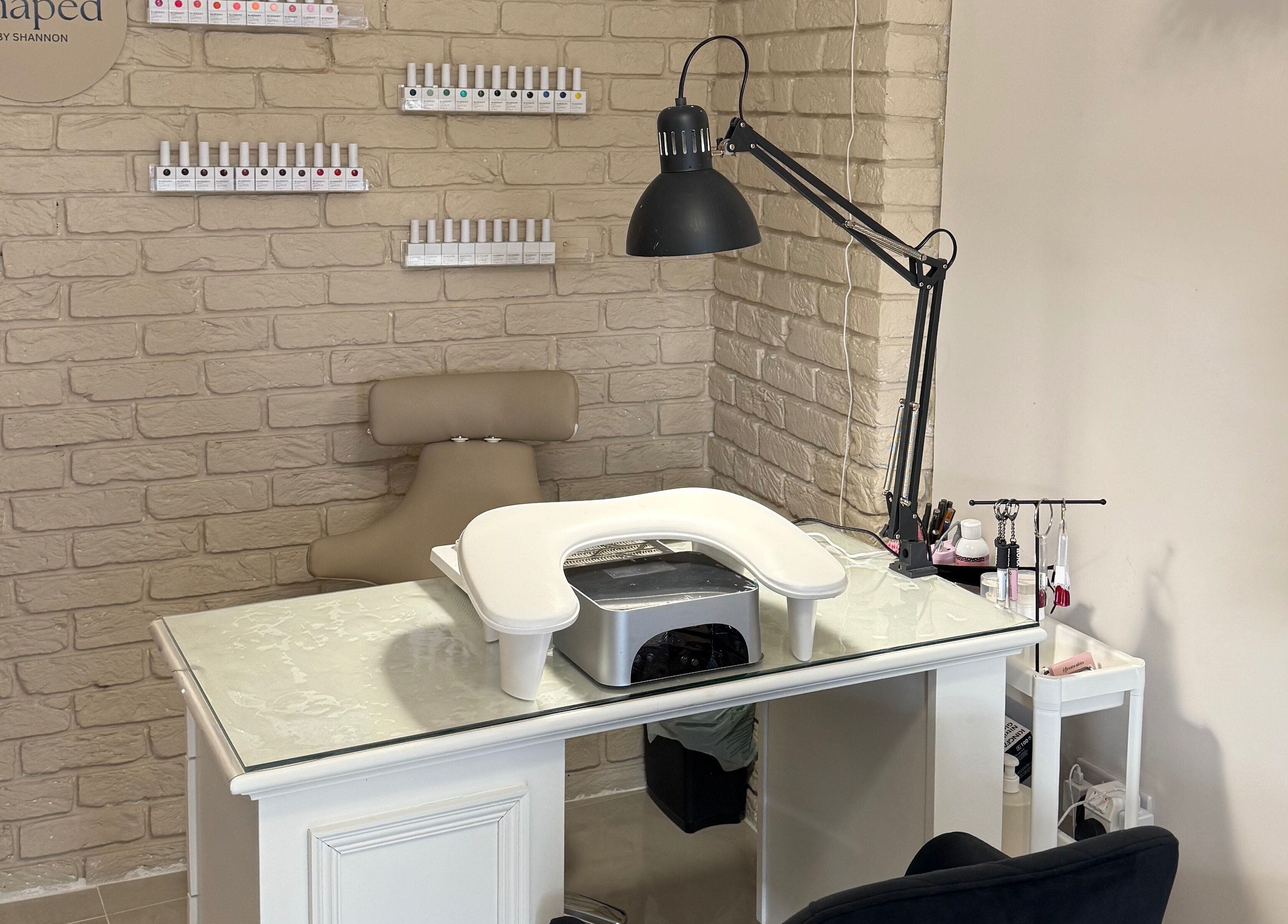 Nail station at Shaped by Shannon in Stafford, England, GB, featuring chic decor and manicure tools.