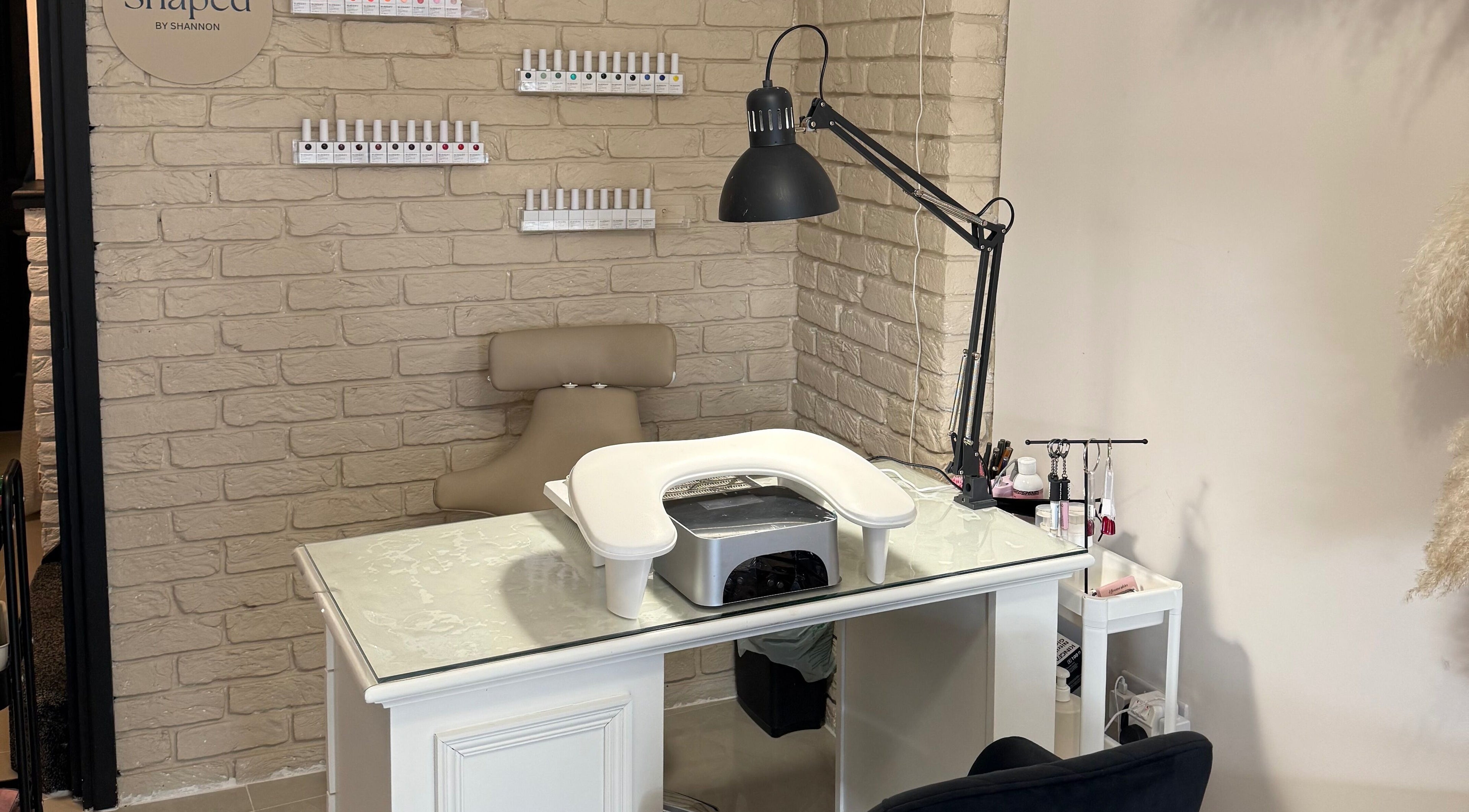 Nail station at Shaped by Shannon in Stafford, England, GB, featuring chic decor and manicure tools.