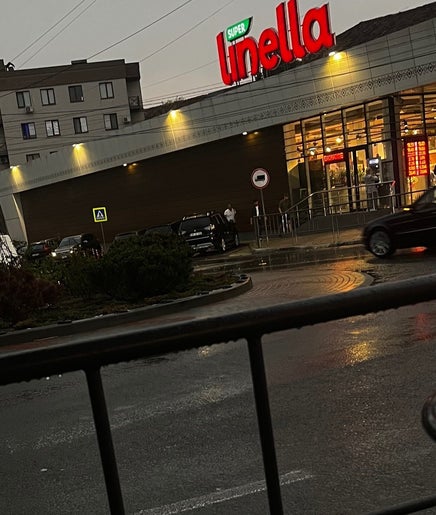 Picky Blades Barbershop near bustling market in Durleşti, Chișinău, MD during a rainy evening.