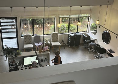 Bright, elegant interior of Sykes Sports Massage Therapy in Auckland, NZ, featuring chairs and stylish workspace.