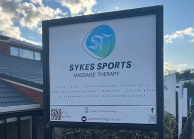 Sign for Sykes Sports Massage Therapy in Auckland, Auckland, NZ under a clear sky.