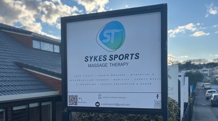 Sign for Sykes Sports Massage Therapy in Auckland, Auckland, NZ under a clear sky.