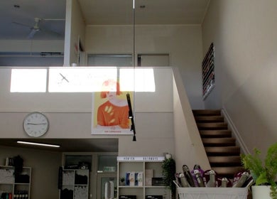Interior of Sykes Sports Massage Therapy in Auckland with stairs leading up to a mezzanine and stylish decor.