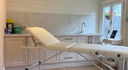 Cozy treatment room at Aesthetically pleasing by lottie, Banstead, England, GB featuring a comfortable spa bed.