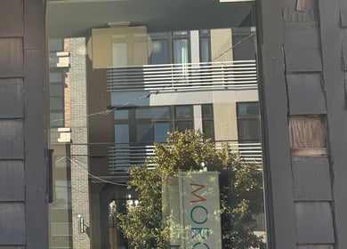 Entrance reflection at ASHIYA'S, Jersey City, New Jersey, US, showcasing sleek urban architecture.