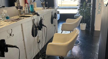 ASHIYA'S salon chairs and styling station in Jersey City, New Jersey, US, featuring white chairs and beauty tools.