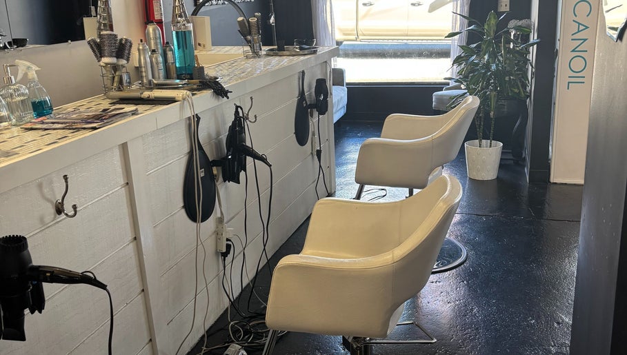 Modern salon styling area at ASHIYA'S, Jersey City, New Jersey, US, featuring white chairs and grooming tools.