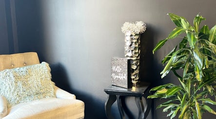 Elegant armchair corner at ASHIYA'S, Jersey City, New Jersey, US with a stylish decor and green plant.