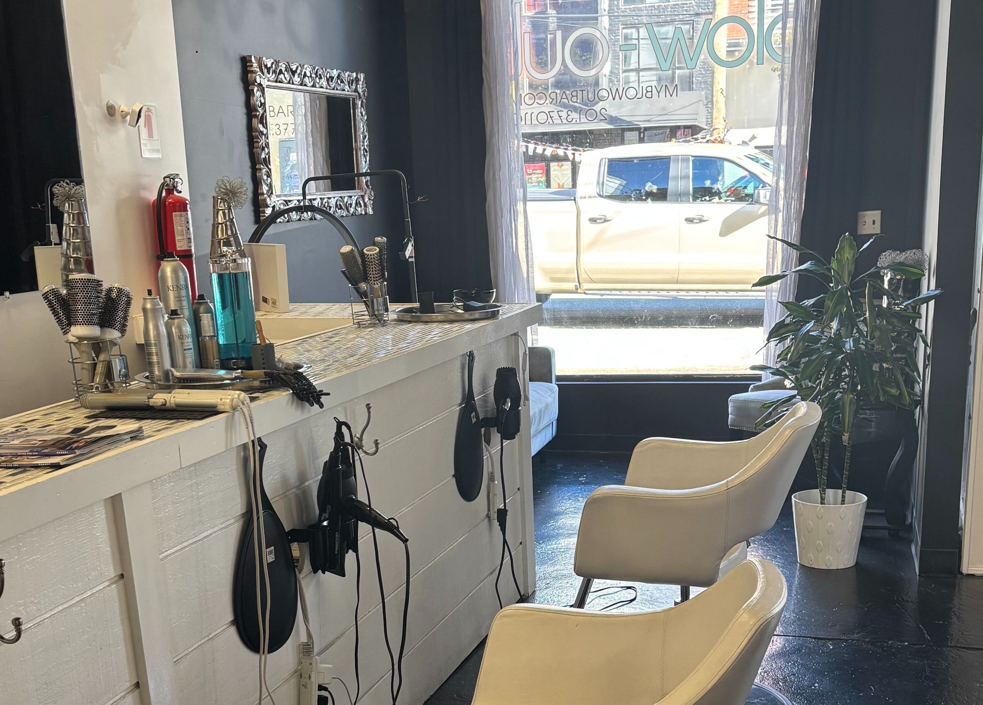 Stylish salon interior at ASHIYA'S in Jersey City, New Jersey, US showcasing chic decor and hair styling tools.
