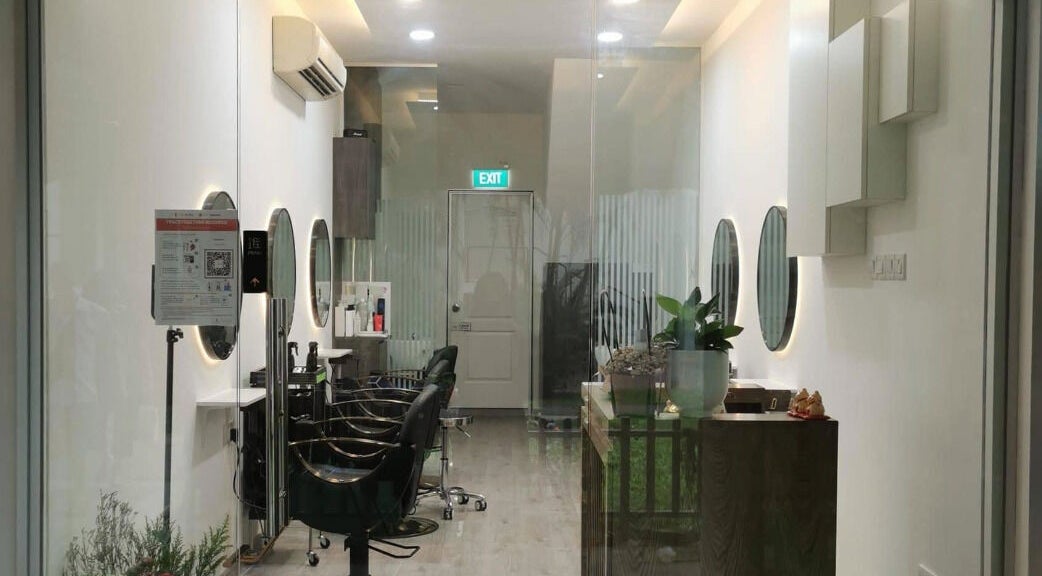 Modern salon interior at J of Salon, Singapore, SG featuring sleek chairs and illuminated mirrors.