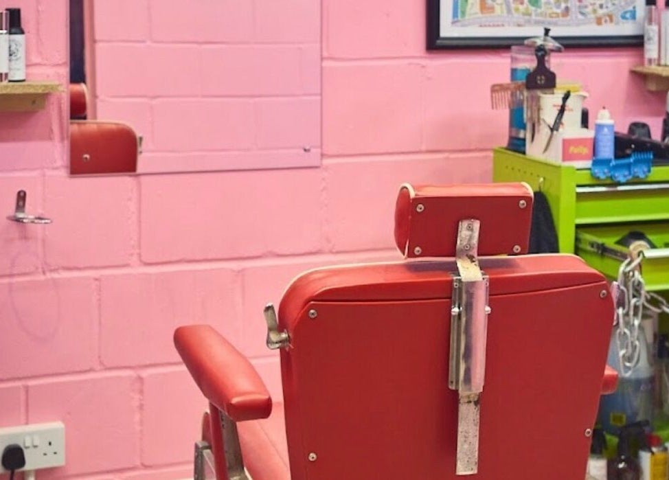 Retro red barber chair at Little Trimz in London, England, GB. Stylish pink and green decor.