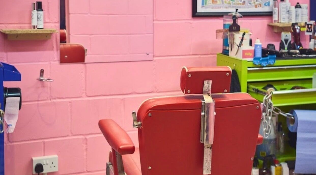 Retro red barber chair at Little Trimz in London, England, GB. Stylish pink and green decor.
