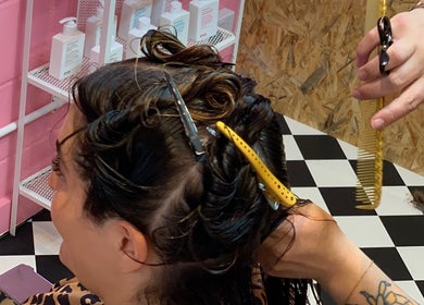 Hair styling in progress at Little Trimz, London, England, GB. Vibrant setting with checkerboard floor.