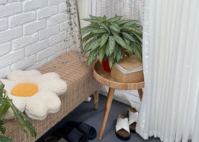 Charming seating area at Peggy Beauty, Lansvale, New South Wales, AU, featuring plants and a floral cushion.