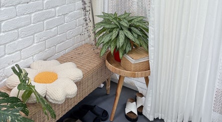 Charming seating area at Peggy Beauty, Lansvale, New South Wales, AU, featuring plants and a floral cushion.