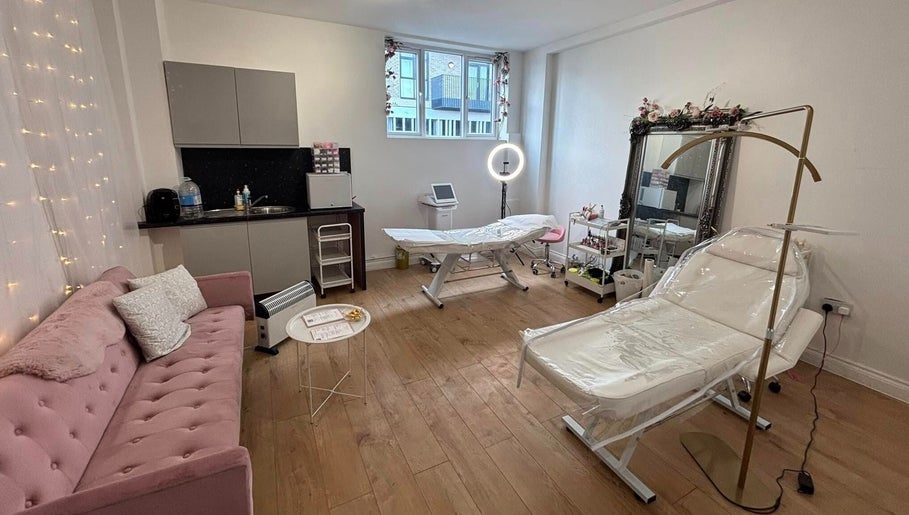 Cozy treatment room at Mia Bella - Wilmslow, Wilmslow, England, GB with pink couch and beauty equipment.