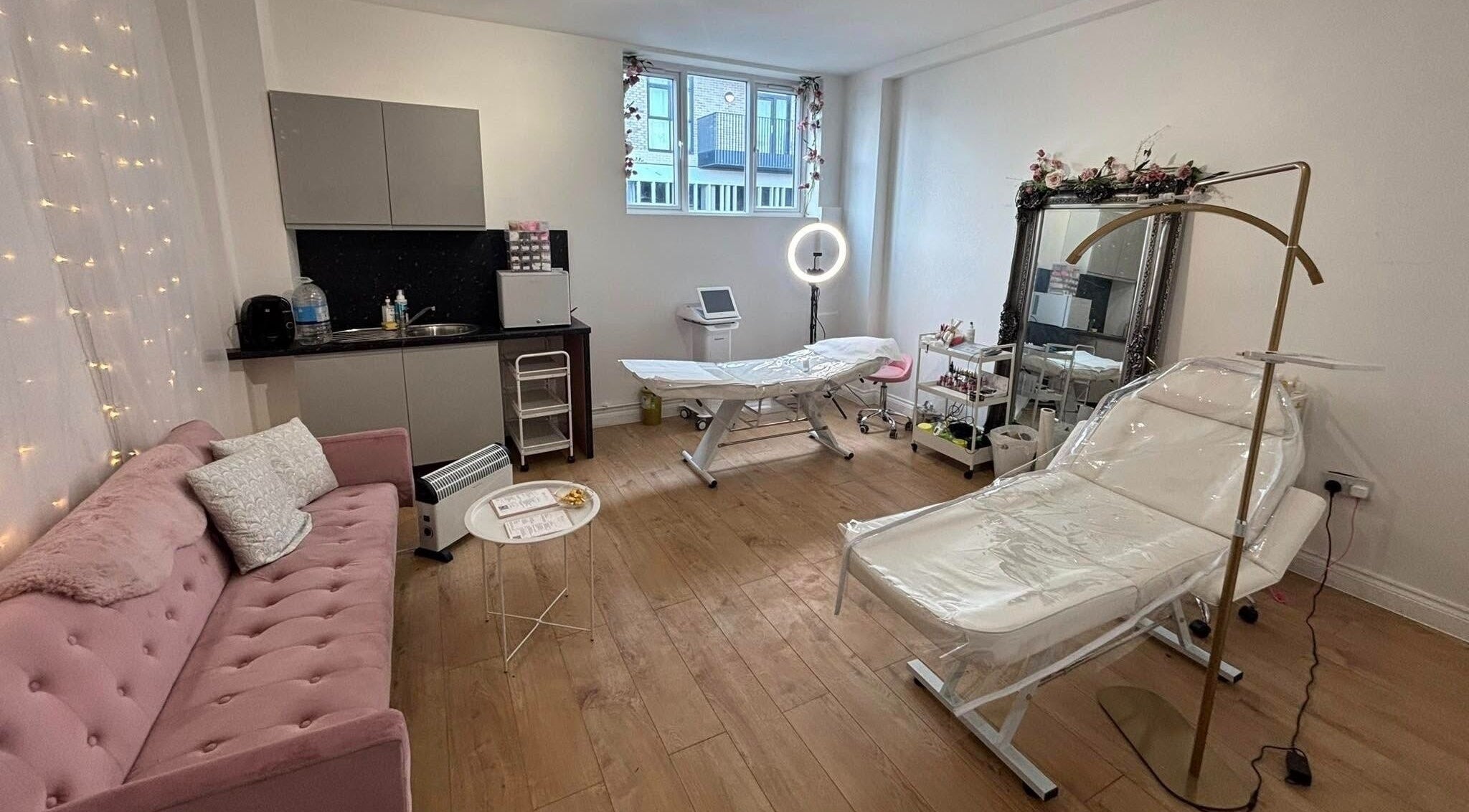 Cozy treatment room at Mia Bella - Wilmslow, Wilmslow, England, GB with pink couch and beauty equipment.