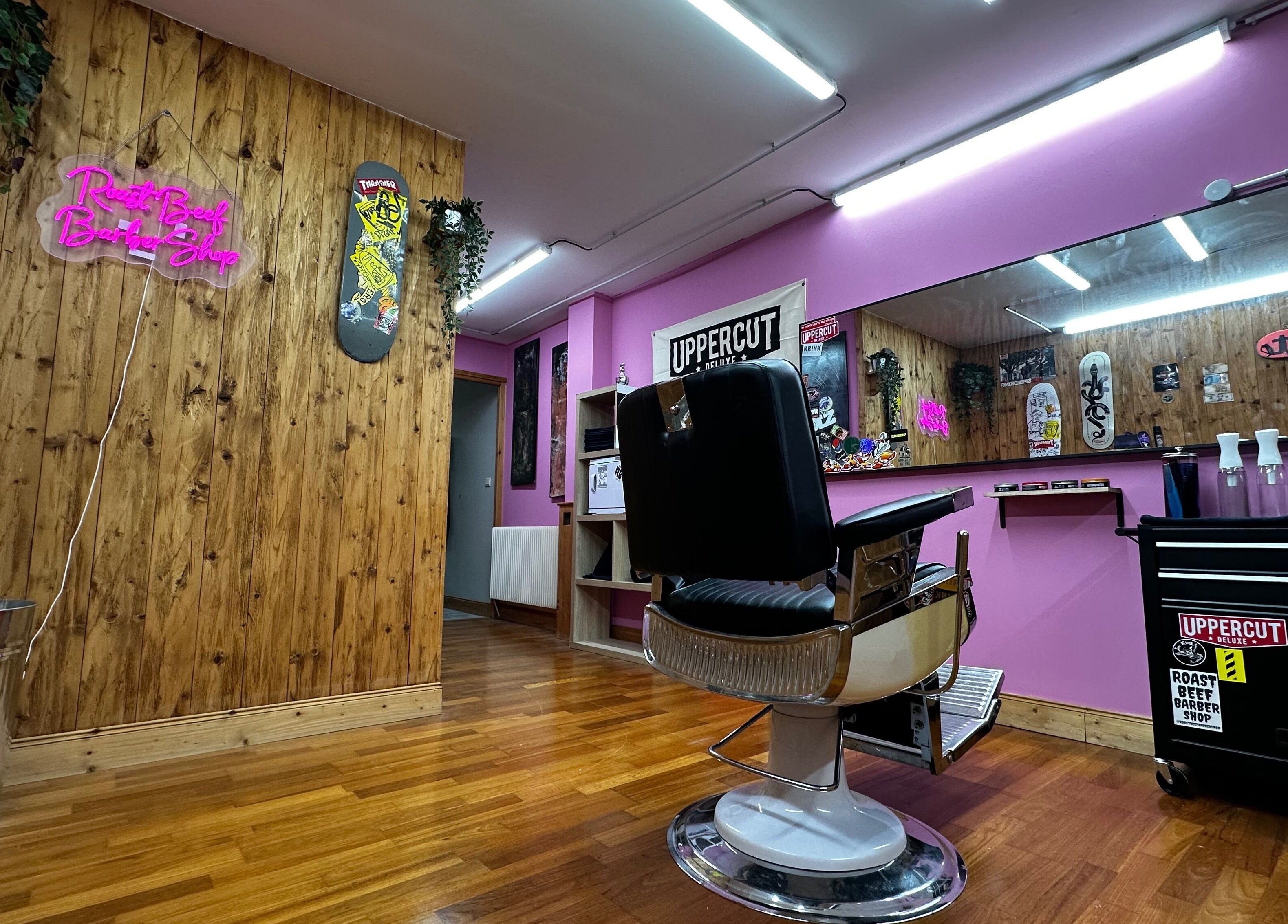 Inside Roast Beef Barber Shop, Samoëns, vibrant pink walls, chic decor, and styling chair.