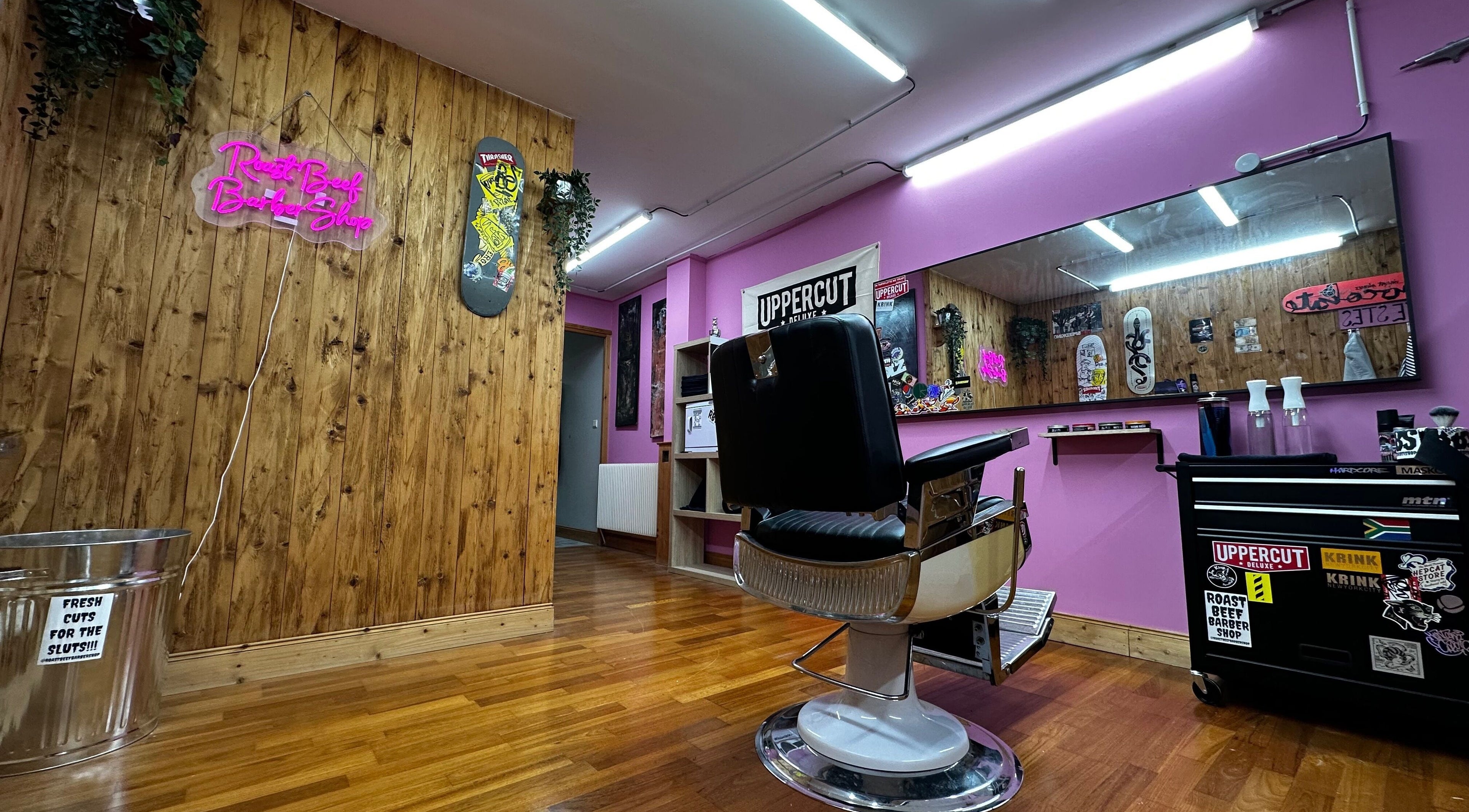 Inside Roast Beef Barber Shop, Samoëns, vibrant pink walls, chic decor, and styling chair.