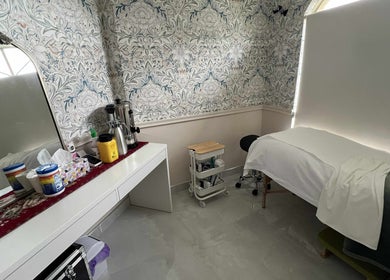 Cozy treatment room at Derma Lift Studio, Winthrop, Western Australia, AU with floral wallpaper and massage table.
