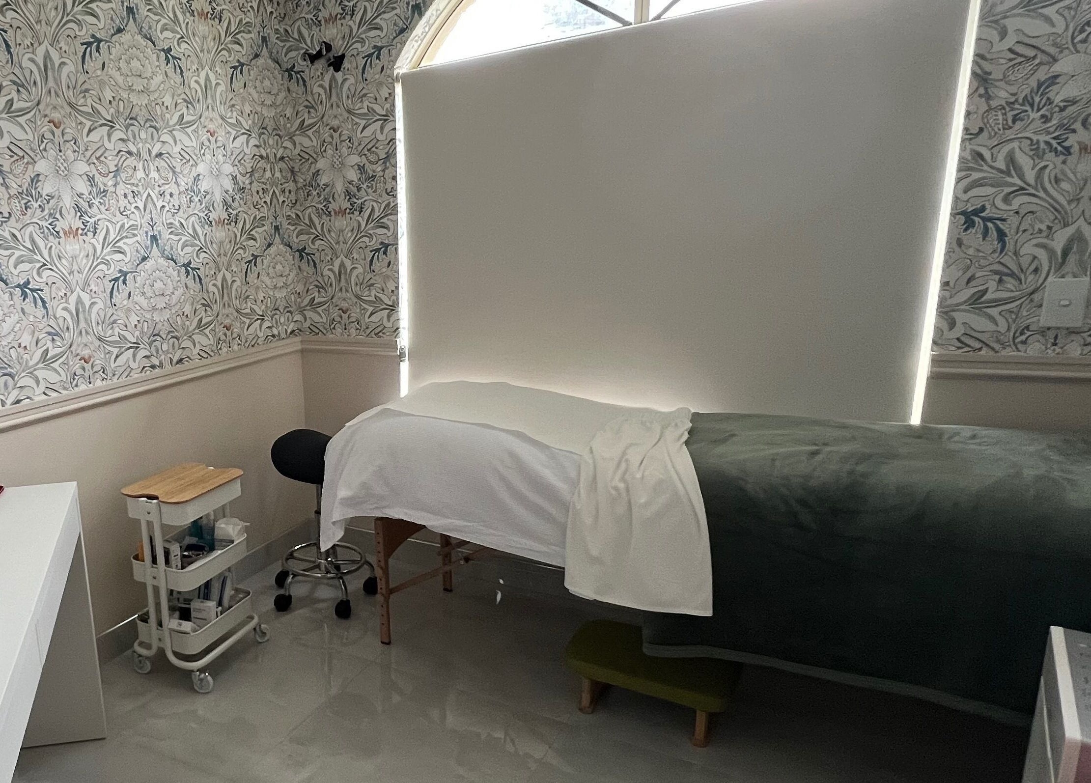 Calming treatment room at Derma Lift Studio, Winthrop, Western Australia, AU, with floral walls and spa bed.