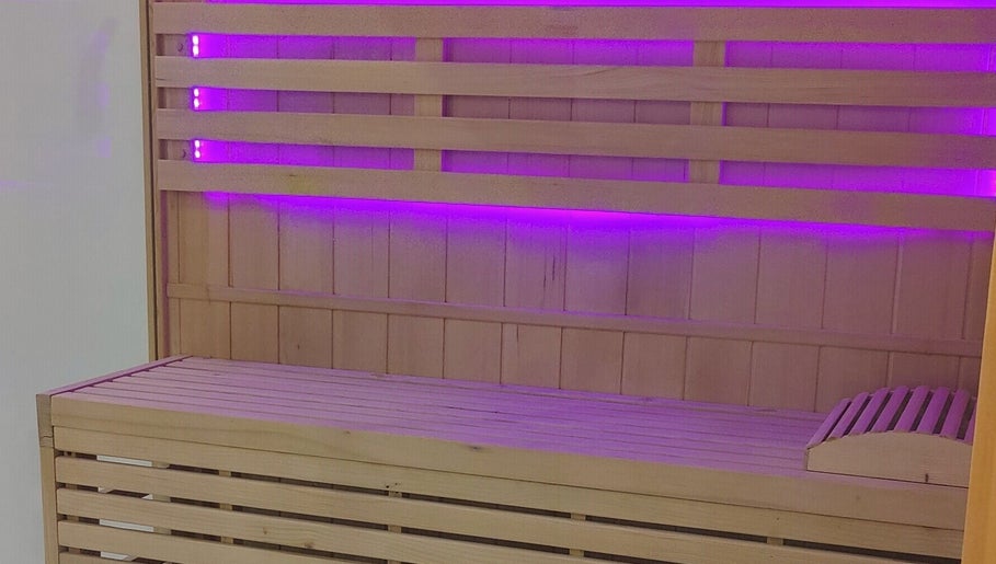 Sauna en bois avec éclairage violet à Epione, Paris, Île-de-France, FR, offrant détente et bien-être.