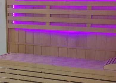 Sauna en bois avec éclairage violet à Epione, Paris, Île-de-France, FR, offrant détente et bien-être.