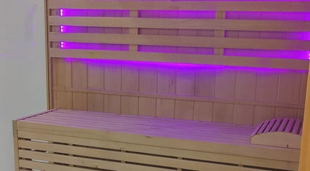 Sauna en bois avec éclairage violet à Epione, Paris, Île-de-France, FR, offrant détente et bien-être.