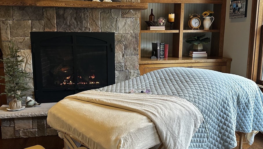 Relaxing spa treatment room at Aquila Health and Beauty | Home Services in Dubai, Dubai, AE with fireplace ambiance.