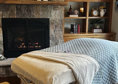 Relaxing spa treatment room at Aquila Health and Beauty | Home Services in Dubai, Dubai, AE with fireplace ambiance.