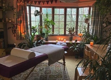Tranquil spa room at Aquila Health and Beauty | Home Services, Dubai, Dubai, AE with massage table and plants.