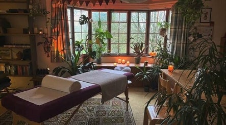 Tranquil spa room at Aquila Health and Beauty | Home Services, Dubai, Dubai, AE with massage table and plants.