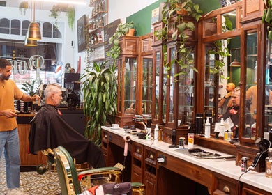 Barber styling hair at Porem Damsquare, Amsterdam, Noord-Holland, NL, vintage interior.
