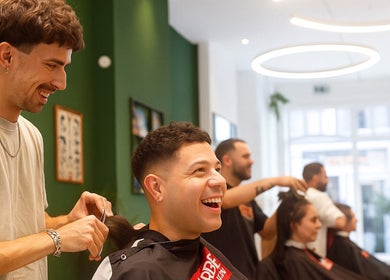 Lively haircut scene at Porem Damsquare in Amsterdam, Noord-Holland, NL, showcasing happy clients and skilled stylists.
