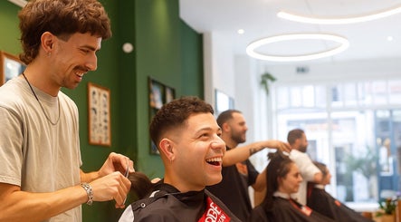 Lively haircut scene at Porem Damsquare in Amsterdam, Noord-Holland, NL, showcasing happy clients and skilled stylists.